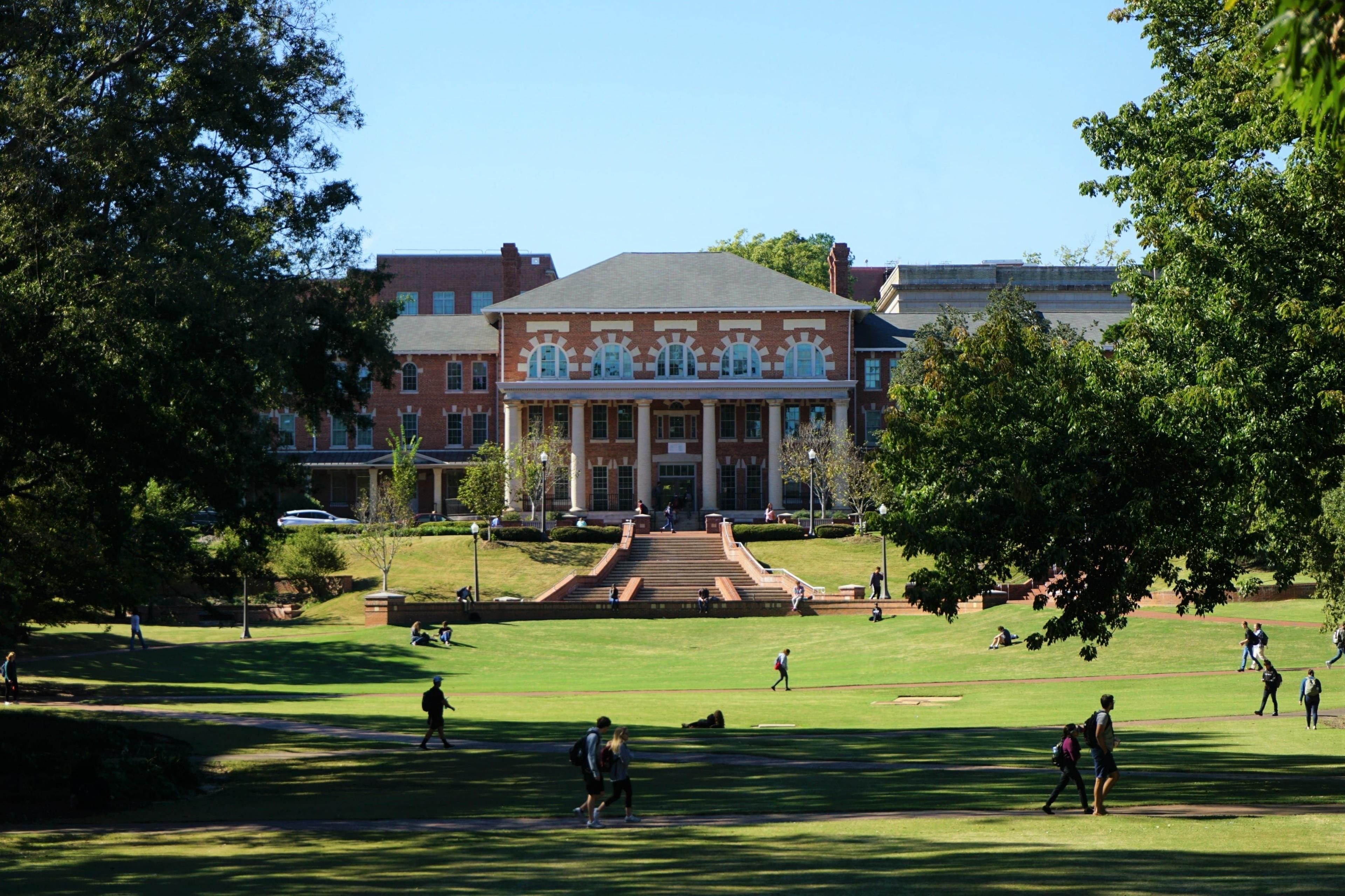 Students walking on the lawn of a college 