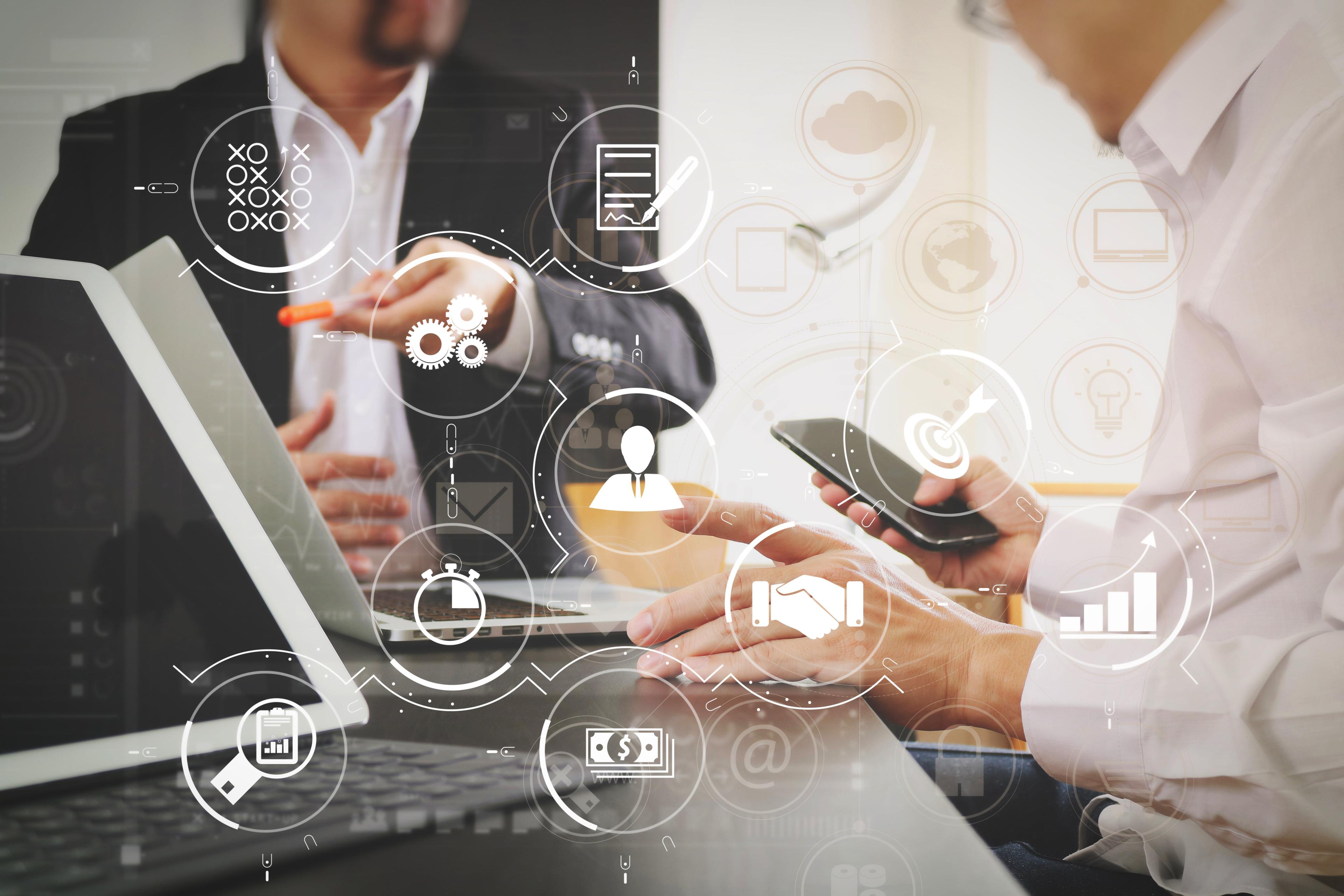 image of two employees working together on shared computer screen in office 