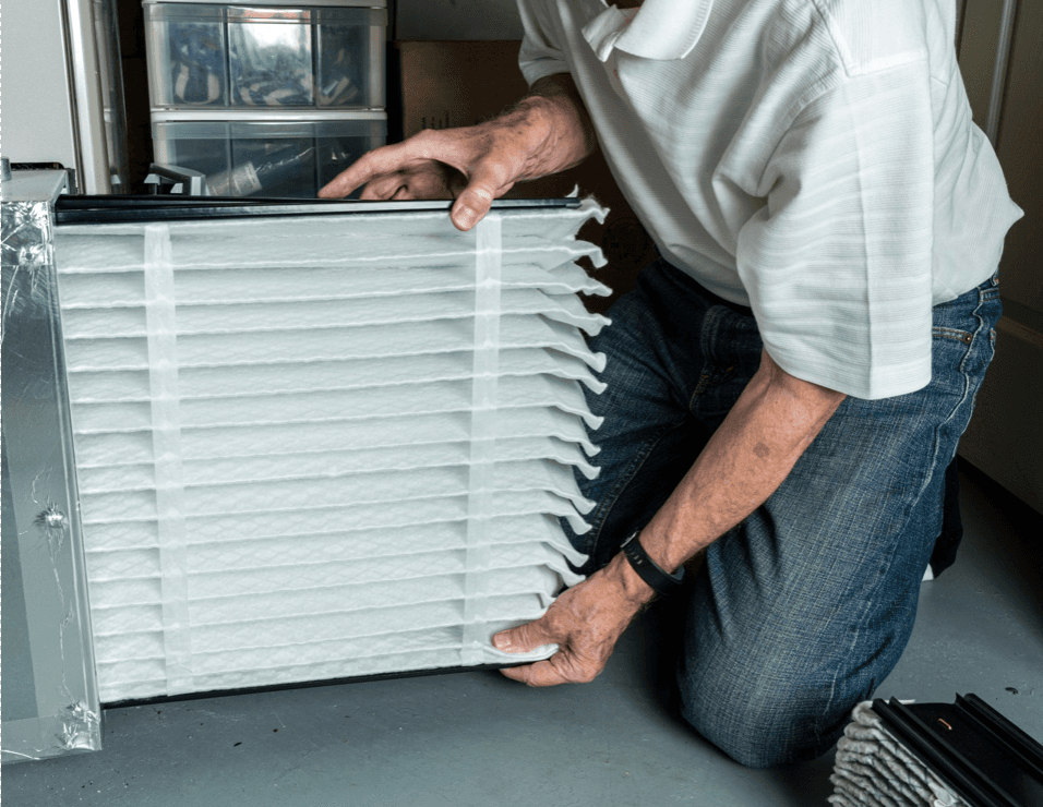 furnace technician replaces furnace filter.