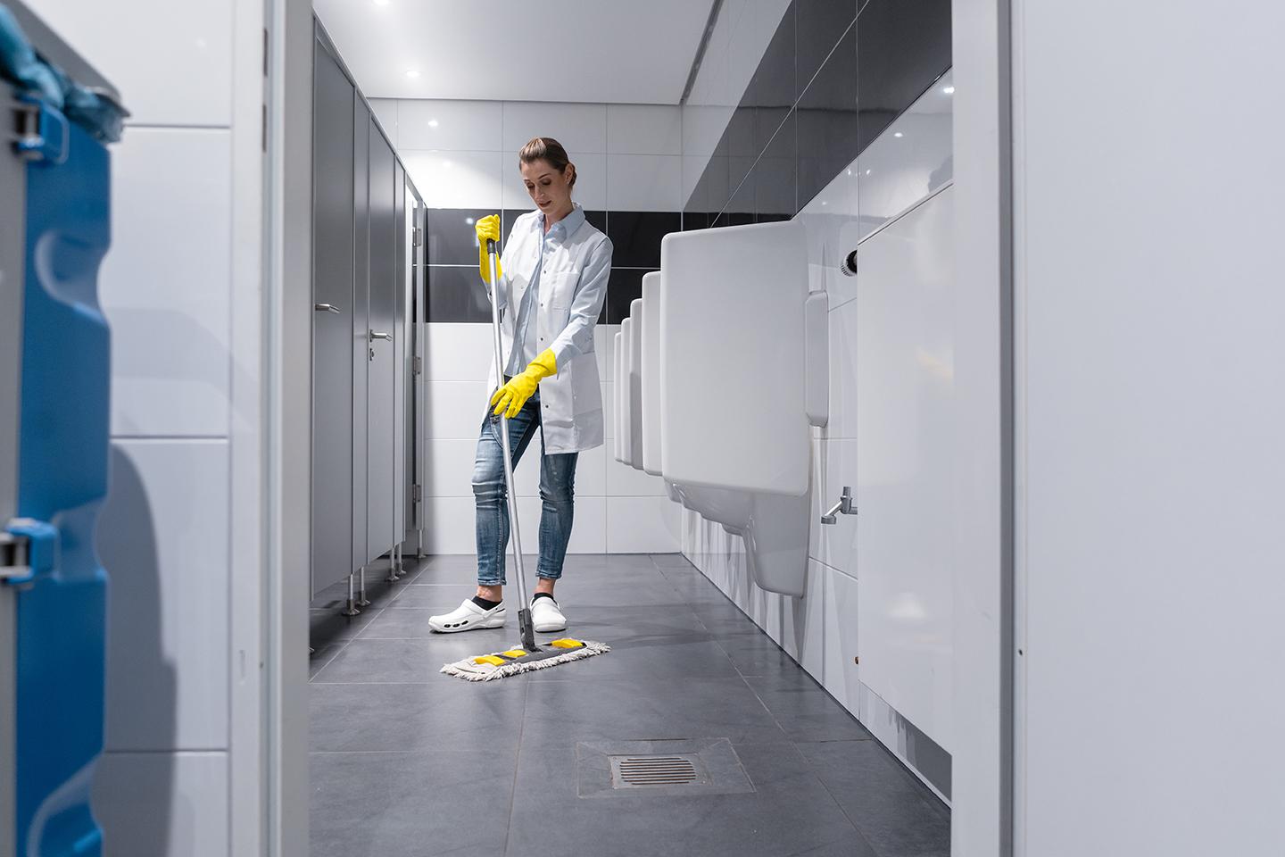 cleaning staff mopping restrooms in Office building