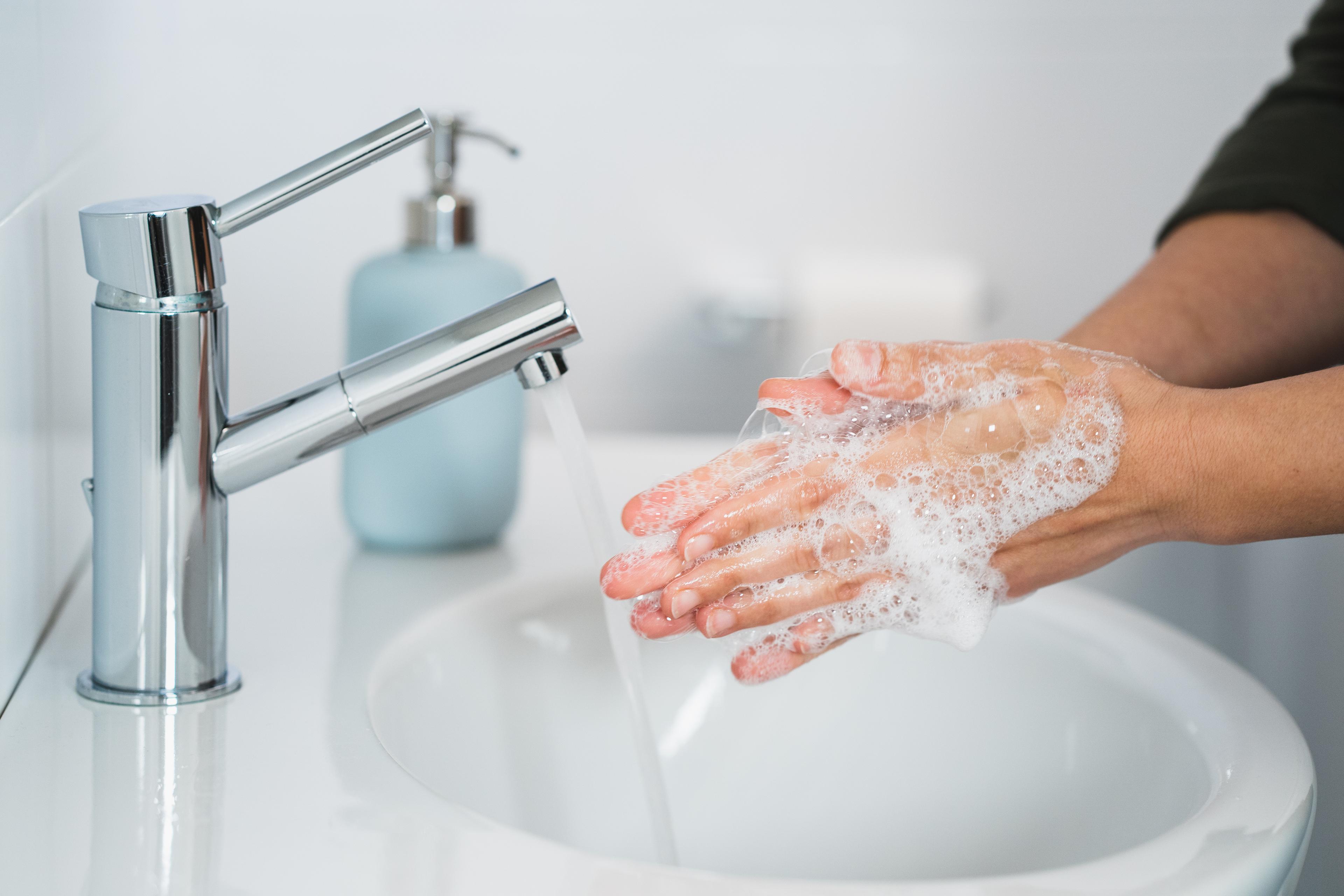 person washing hands to help stop the spread of germs at work