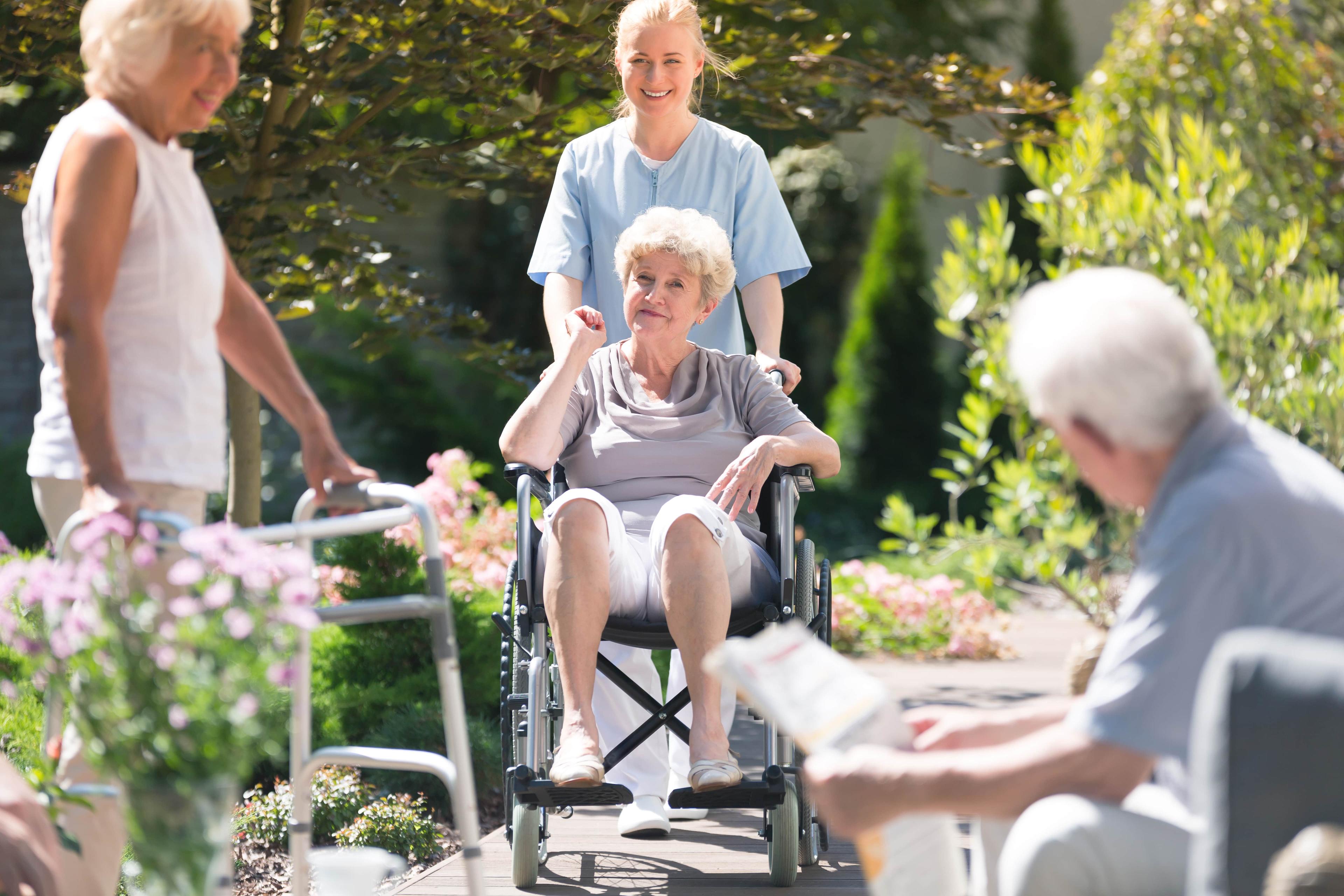 four seniors enjoying eco-friendlhy outdoor garden at senior living community