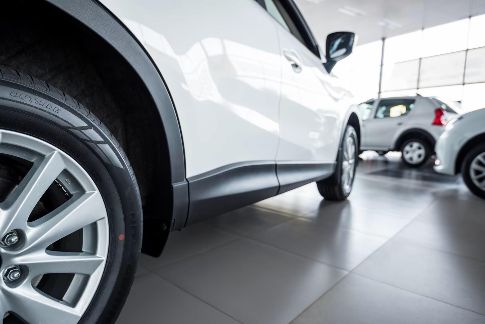 up close image of car and floor in car dealership highlighting how clean the facility is